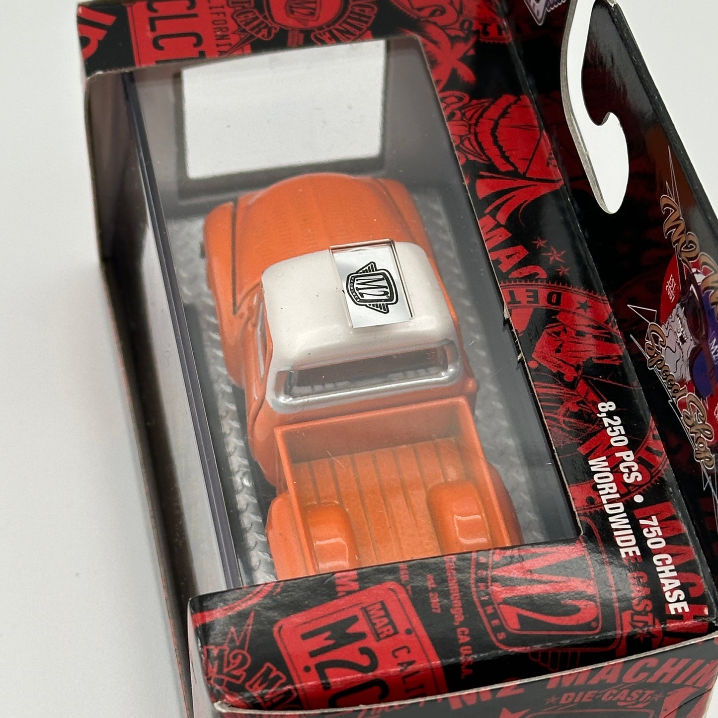 Orange toy car in a black and red packaging with M2 branding